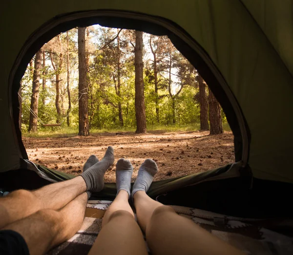 Young couple resting in camping tent, view from inside — Stock Photo, Image