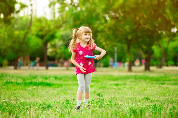 Gyermek lány játszik egy Frisbee a nyári parkban — Stock Fotó