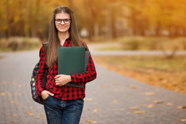 Parkta sırt çantası olan bir öğrenci. Güzel öğrenci kız yakın.