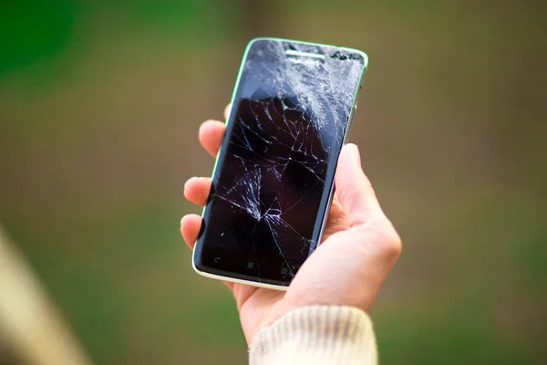 Joven hombre mantenga roto la pantalla del teléfono inteligente. Teléfono roto en la mano — Foto de Stock