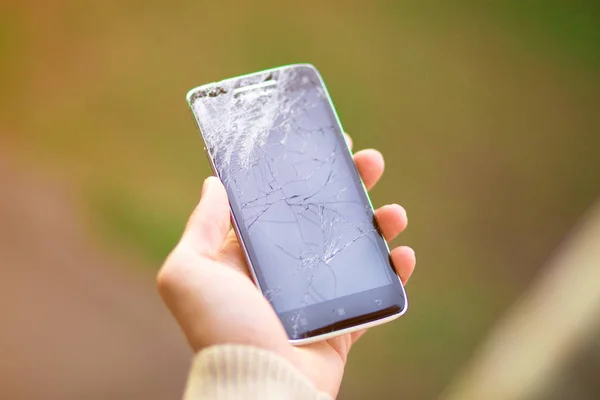 young man hold broken smartphone screen. Broken phone in hand