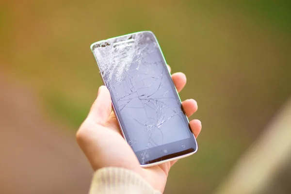 Joven hombre mantenga roto la pantalla del teléfono inteligente. Teléfono roto en la mano — Foto de Stock