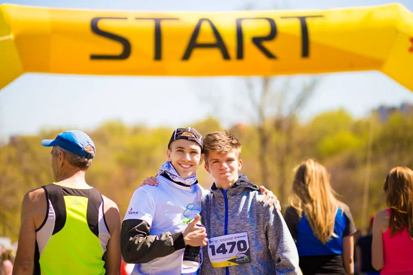 Krivoy Rog, Ucrania - 21 de abril de 2019: Grupo de jóvenes atletas en posición de inicio. Ajustar a los jóvenes que se preparan para los participantes de maratón inicio a distancia — Foto de Stock