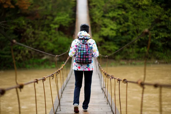 Mujer con mochila senderismo Estilo de vida aventura concepto bosque y cruzar el río en el bosque vacaciones activas en la naturaleza —  Fotos de Stock