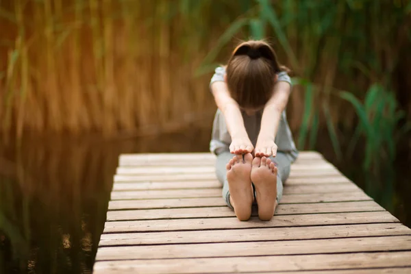 Niño haciendo ejercicio en la plataforma al aire libre. Estilo de vida saludable. Chica de yoga —  Fotos de Stock