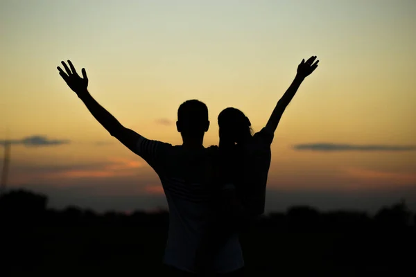 Silhouetten von Vater und Tochter auf seinen Schultern mit erhobenen Händen, die sich vor Sonnenuntergang amüsieren. Elternschaft, Familienaktivitäten, Strandurlaub und Urlaub, Unterstützung und Liebesthemen — Stockfoto