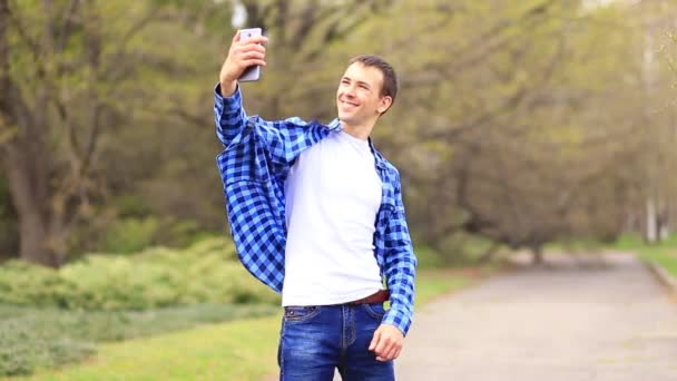 Young Man Takes Selfie Portrait While Walkind Spring Park — Stock Video
