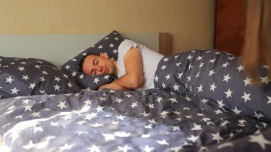 Mutlu küçük kız, uyuyan babasını sabahın erken saatlerinde yatağında uyandırıyor. İnsanlar, aile ve sabah konsepti