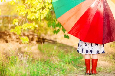 Mutlu çocuk kız yürümek yağmur altında çok renkli şemsiye ile