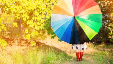 Mutlu çocuk kız yürümek yağmur altında çok renkli şemsiye ile