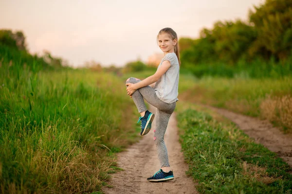 Bambina che fa esercizi di fitness all'aperto a surise — Foto Stock