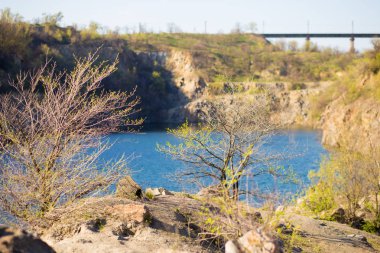 Mavi göl. Demir cevheri ocağıtaşlı kumlu dik banka, zümrüt su ile göl. Doğal manzara. Seyahat ve turizm.