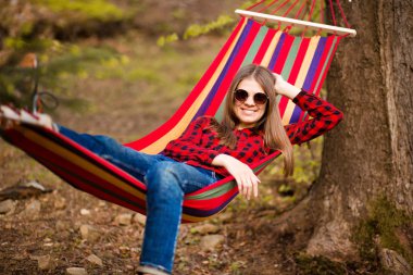 Mutlu yaşam tarzı kavramı. Orman güneş gözlüğü güzel kaygısız kadın hamak üzerinde dinlenirken açık havada mutlu olmak. olumlu tutum.