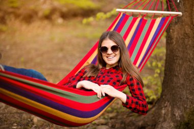 Kaygısız mutlu kadın doğa ile uyum zevk hamak üzerinde yatan. Özgürlük. Zevk. Ormanda dinleniyorum. Hayal