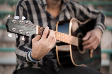 İskambil gitar ve şarkı, müzik konsepti basamaklarında oturan genç adam