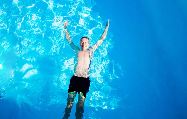 Happy man is zwemmen in zwembad van Top View. Zomervakantie — Stockfoto
