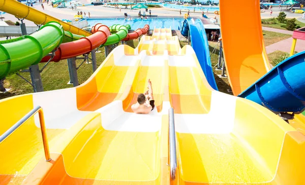 Bovenaanzicht van Happy Crazy man bovenop Slide in Aqua Park-jonge mensen die plezier hebben in de zomer vakantie-vakantie, jeugd en reis concept — Stockfoto