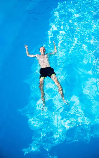 Happy man is zwemmen in zwembad van Top View. Zomervakantie — Stockfoto