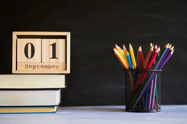 Bril stand met potloden op tafel, op achtergrond van Blackboard met krijt. Concept van leraren dag. Ruimte kopiëren. — Stockfoto