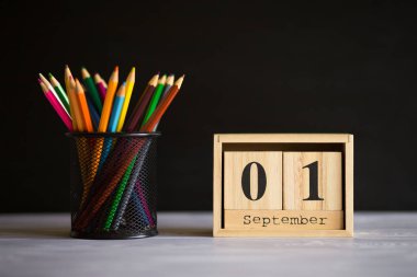 Gözlük ler masanın üzerinde kalemlerle, tahtanın arka planında tebeşirle duruyor. Öğretmenler günü kavramı. Kopyalama alanı.