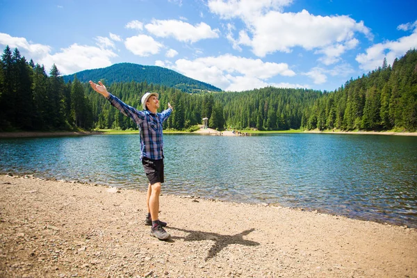 Fri man med öppna armar nära fjällsjön. framgång. Resa och frihet koncept. Ett bra liv. — Stockfoto