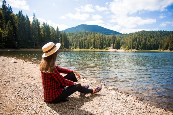 Hermosa mujer en sombrero relajante cerca de las montañas lago. Concepto de vacaciones — Foto de Stock