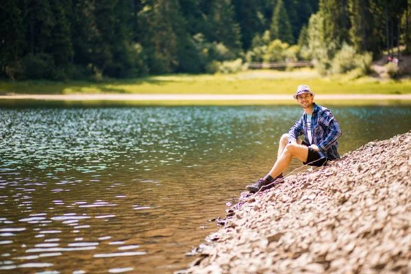 Toeristische jongeman wandelen op het bos meer strand in de zomer. Vakantieconcept — Stockfoto