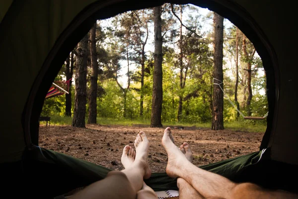 Young couple resting in camping tent, view from inside — Stock Photo, Image