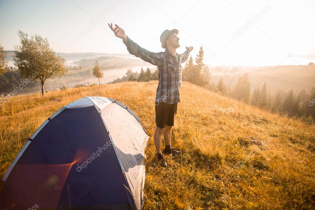 Happy hiking travel on top of mountain hand up looking to sunrise. Camp travel concept