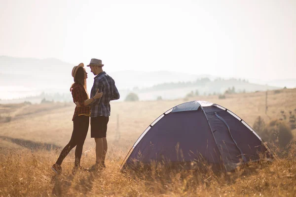 Happy Tourist para chodzić na szczycie góry w pobliżu namiotu i cieszyć się jesienią rano w wakacje. Styl życia obozu — Zdjęcie stockowe