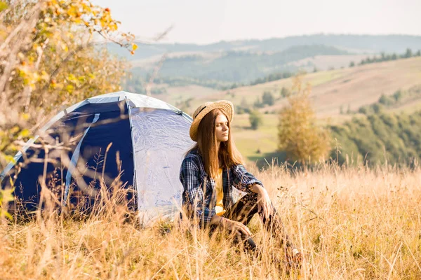 Young woman in straw hat meets autumn morning in touristic camping tent. Romantic camp traveling concept. — Stock Photo, Image