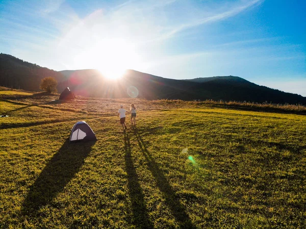 Vista aérea del amor pareja de excursionistas pasar tiempo juntos lejos del bullicio de la ciudad al amanecer en el día de camping —  Fotos de Stock