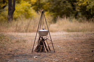 Sonbahar ormanlarında kamp ateşinde yemek hazırlamak.