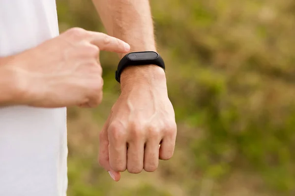 Läufer auf Bergpfaden schauen auf Sport-Smartwatches, überprüfen Leistung oder Puls. Sport und Fitness in der Natur. — Stockfoto