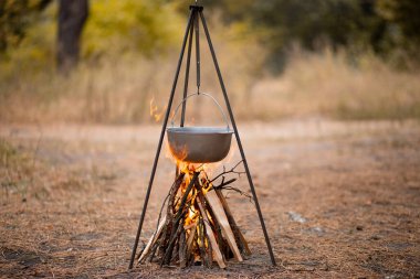Sonbahar ormanlarında kamp ateşinde yemek hazırlamak.