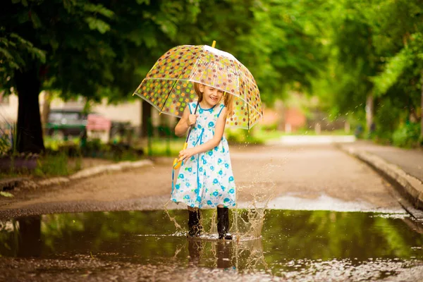 夏の散歩に傘とゴムのブーツを着た幸せな子供の女の子 — ストック写真