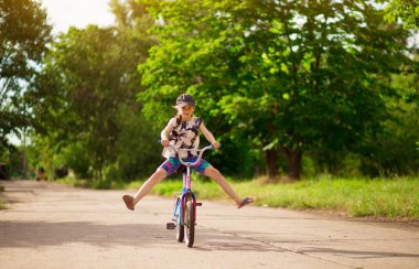Küçük kız parkta bisiklet sürmeyi öğreniyor. Etkin çocukluk