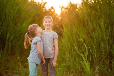 Tatlı küçük kız kardeşler yazın sarılıp öpüşüyorlar.