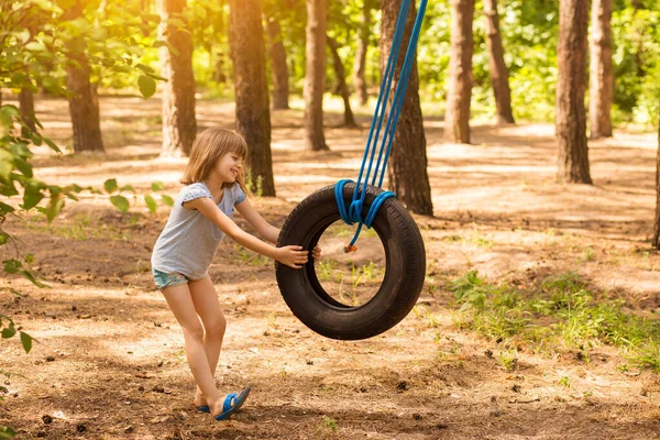 Felice Bambina Attiva Che Gioca Sulla Ruota Oscillante Nella Foresta — Foto Stock