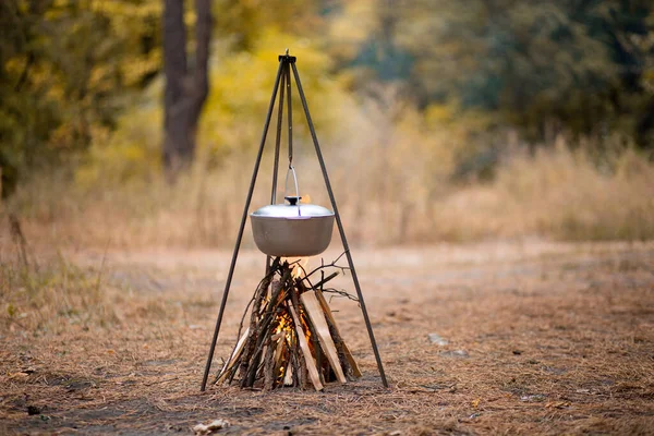 Sonbahar ormanlarında kamp ateşinde yemek hazırlamak.