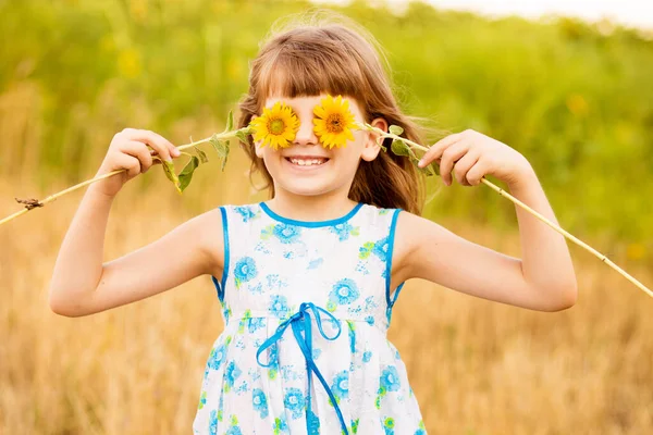 Fröhliches Mädchen Lächelt Und Bedeckt Gesicht Mit Sonnenblume Sommerfeld — Stockfoto