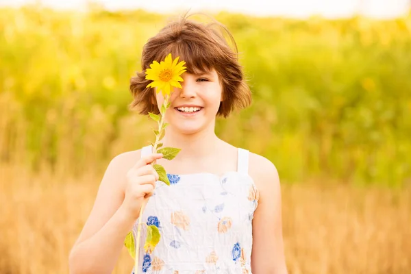 Fröhliches Mädchen Lächelt Und Bedeckt Gesicht Mit Sonnenblume Sommerfeld — Stockfoto