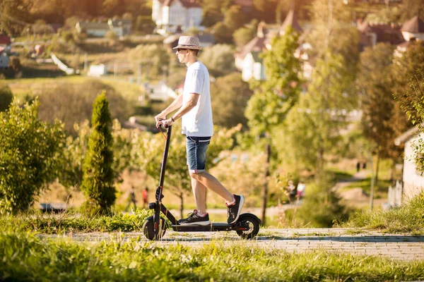 Fiatal Férfi Lovaglás Elektromos Robogó Parkban Csodálatos Őszi Kilátással — Stock Fotó