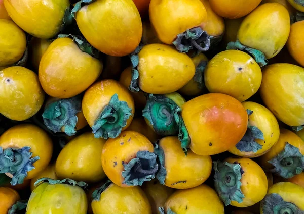 Fonis de caqui en el mercado. Frutas maduras en el mostrador . — Foto de Stock