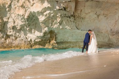 Güzel gelin ve damat yalnız bir Yunan adasının sahilinde