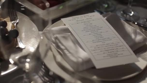 Mariage. Un banquet. Les chaises et la table ronde pour les invités, servis avec couverts et vaisselle et recouverts d'une nappe bleue . — Video