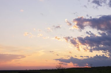 Günbatımı ile bulutlar tepenin üzerinden