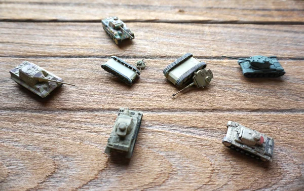 Eski oyuncak tank ahşap arka plan üzerinde Muharebesi. 