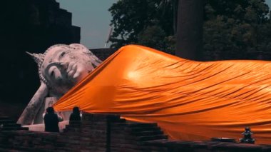 Ayutthaya, Tayland - 5 Nisan 2019 : Gezginler Wat Yai Chaimongkol tapınağında buda heykelinin sarı cüppesiyle giydirilir.