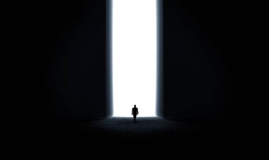 Işık kapısının önünde duran işadamının silueti.